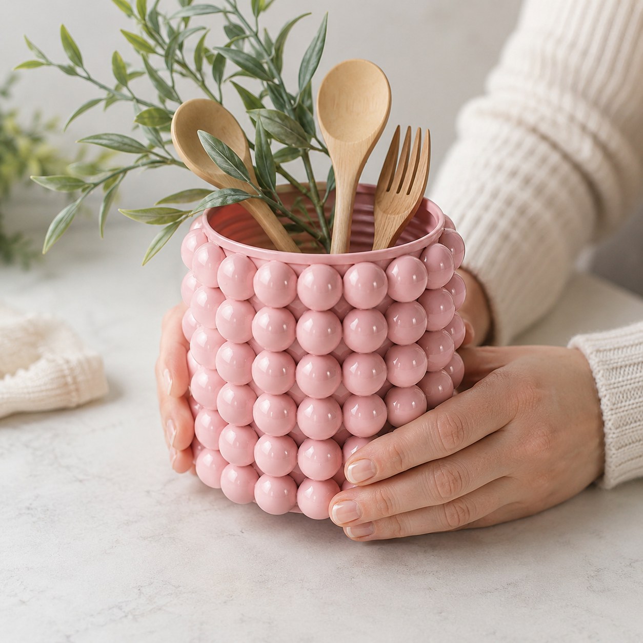 Mit rosa Perlen beklebte Tablettenflasche als dekoratives Utensilo für Kochlöffel in der Küche