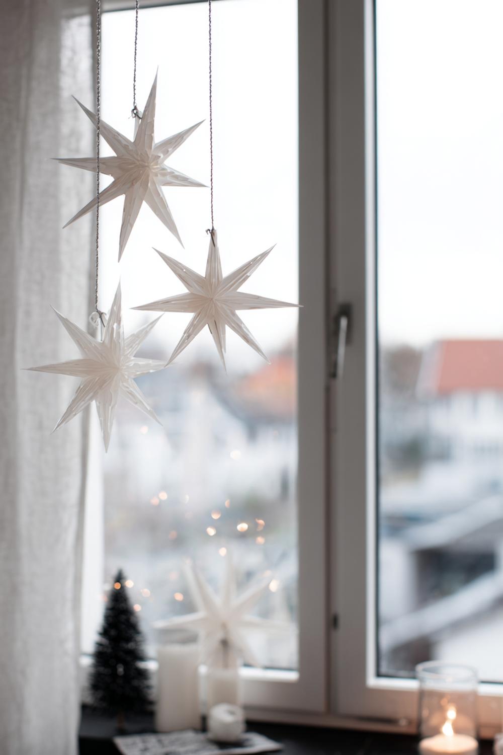 3. Weihnachtsdeko minimalistisch Wohnung: Monochrome Papiersterne am Fenster mit feiner schwarzer Kordel